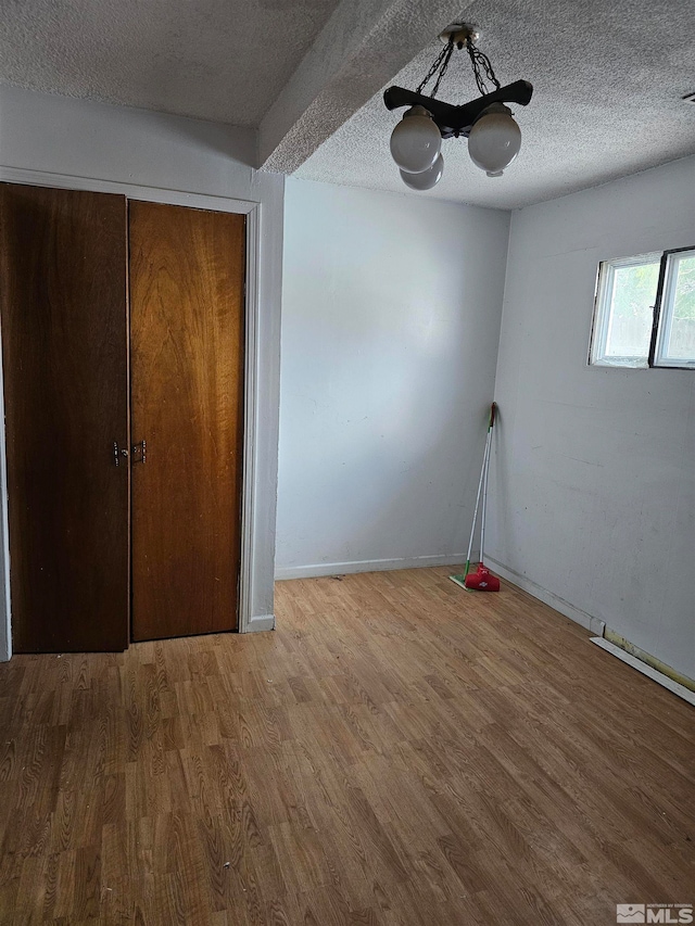 interior space with a textured ceiling and hardwood / wood-style flooring