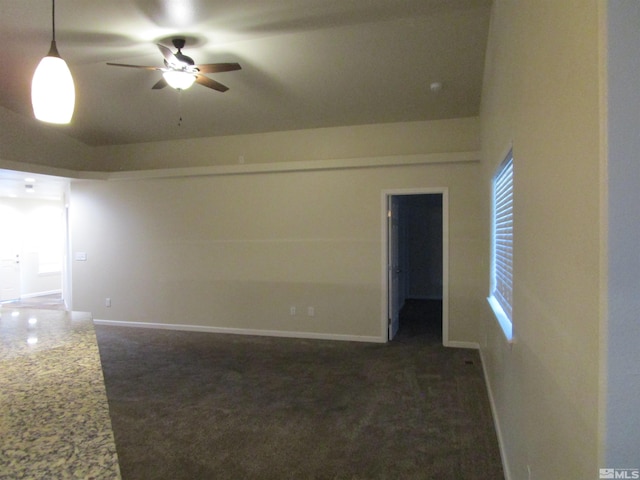 spare room featuring vaulted ceiling, ceiling fan, and dark carpet