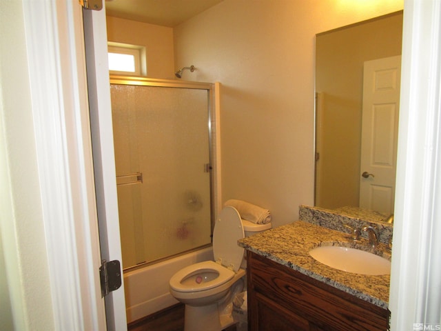 full bathroom featuring bath / shower combo with glass door, toilet, and vanity