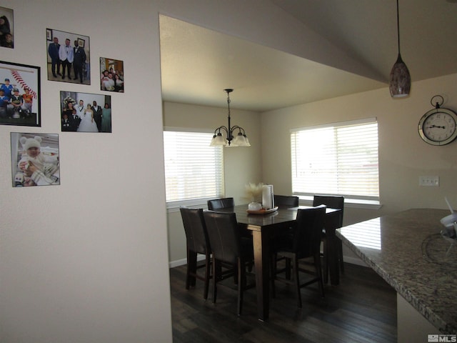 dining room with vaulted ceiling, an inviting chandelier, a wealth of natural light, and dark hardwood / wood-style floors