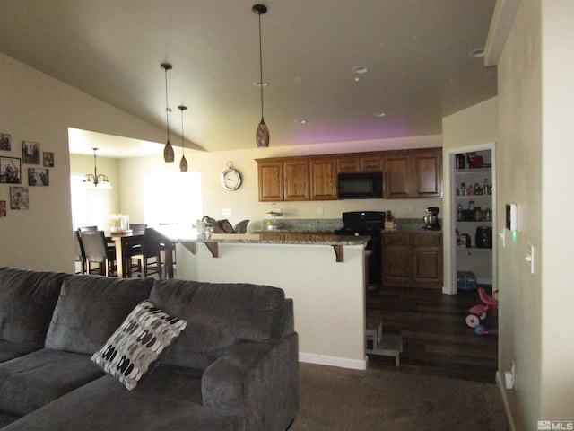 kitchen with decorative light fixtures, vaulted ceiling, black appliances, a kitchen bar, and an inviting chandelier