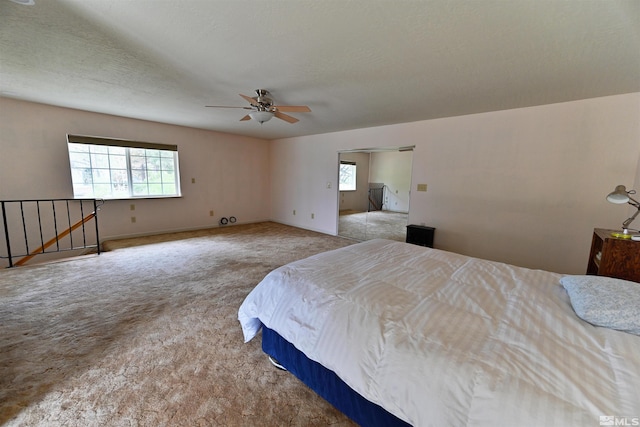 carpeted bedroom with ceiling fan, a textured ceiling, and multiple windows