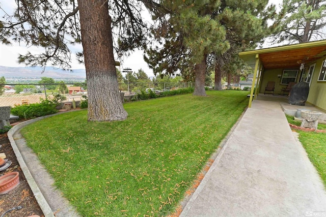 view of yard with a carport and a mountain view