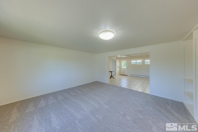 unfurnished room with light colored carpet, a textured ceiling, and a baseboard heating unit