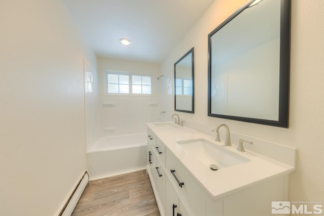 bathroom with a baseboard heating unit, hardwood / wood-style floors, and vanity