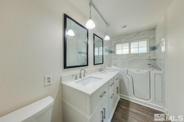 bathroom featuring toilet, a bathing tub, hardwood / wood-style flooring, and vanity