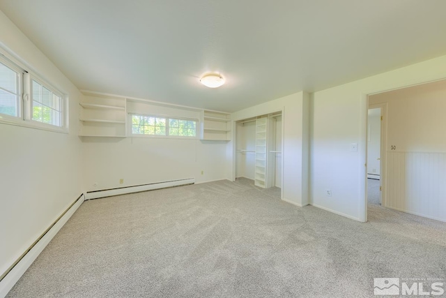 unfurnished bedroom featuring light colored carpet, a baseboard heating unit, and a closet