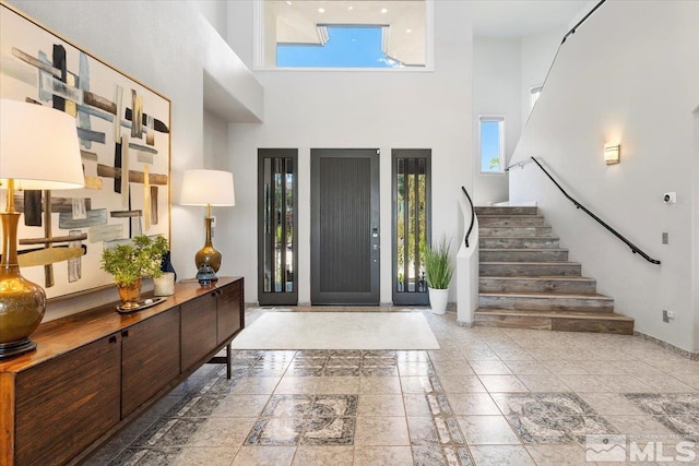 entrance foyer with a towering ceiling and stairs