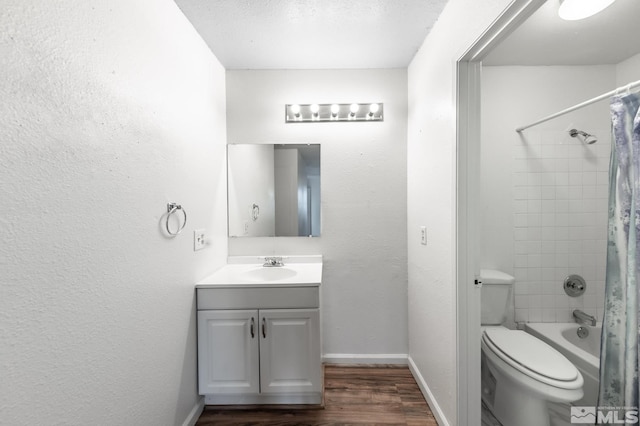 full bathroom with shower / bath combo, hardwood / wood-style floors, a textured ceiling, toilet, and vanity