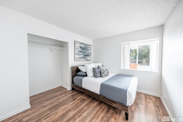 bedroom featuring a closet, a textured ceiling, and wood-type flooring