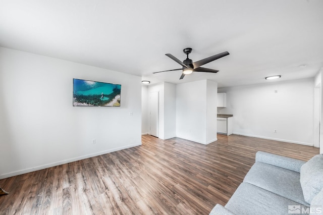 unfurnished living room with ceiling fan and dark hardwood / wood-style flooring