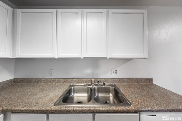 kitchen featuring white cabinets, dishwasher, and sink