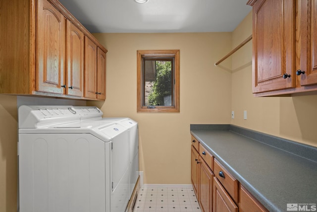 laundry room featuring cabinets, light tile patterned floors, and washing machine and clothes dryer