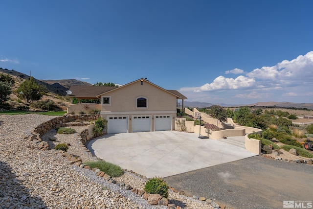 view of side of home featuring a mountain view and a garage