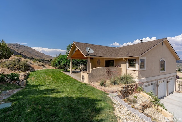 view of front of property featuring a mountain view, a garage, and a front lawn