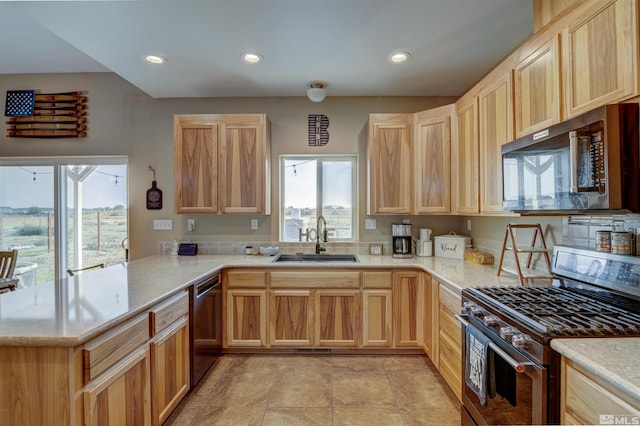 kitchen featuring kitchen peninsula, stainless steel appliances, plenty of natural light, and sink