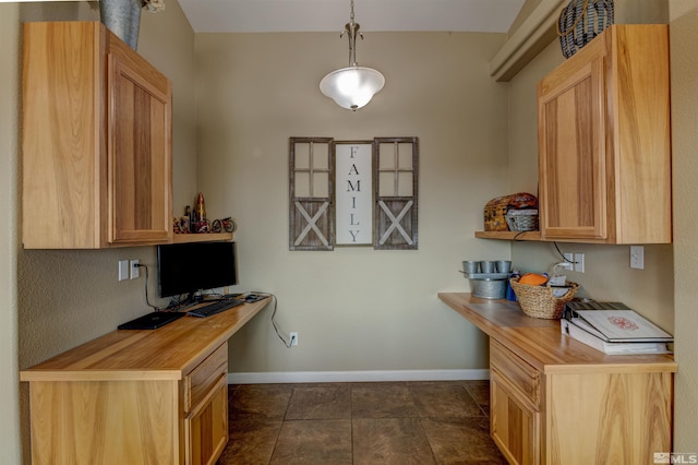 kitchen with light brown cabinetry, dark tile patterned floors, butcher block countertops, and hanging light fixtures