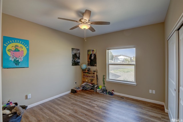 unfurnished bedroom featuring wood-type flooring, a closet, and ceiling fan