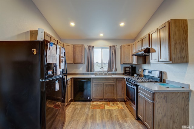 kitchen with sink, light hardwood / wood-style floors, lofted ceiling, and black appliances