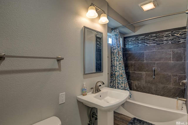 full bathroom featuring sink, shower / bath combination with curtain, and toilet