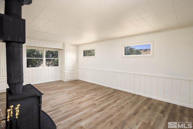 unfurnished living room featuring light wood-type flooring and a wood stove