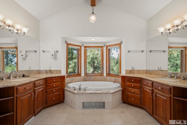 bathroom with vanity, lofted ceiling, and a relaxing tiled tub