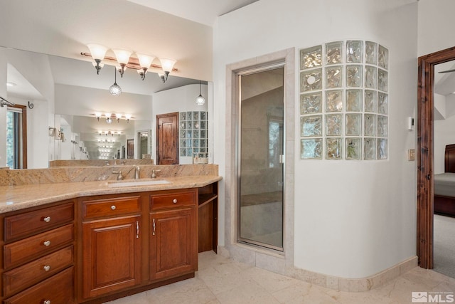 bathroom with a shower with door and vanity