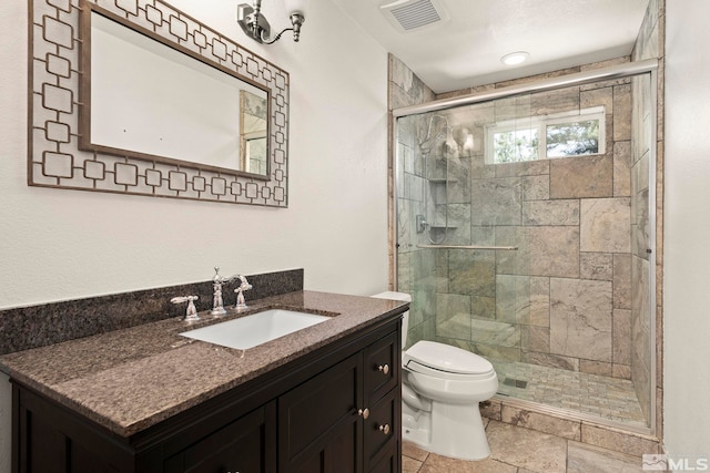 bathroom featuring walk in shower, vanity, and toilet