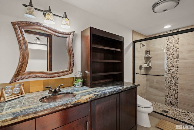 bathroom featuring vanity, tile patterned flooring, toilet, and walk in shower