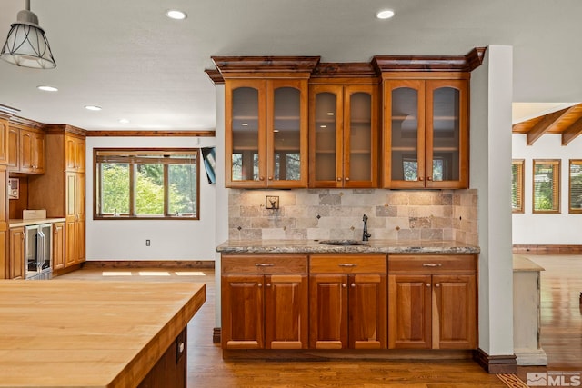 kitchen with pendant lighting, sink, beverage cooler, dark hardwood / wood-style flooring, and decorative backsplash