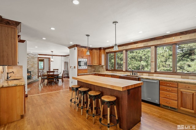 kitchen featuring appliances with stainless steel finishes, sink, light hardwood / wood-style floors, and butcher block countertops