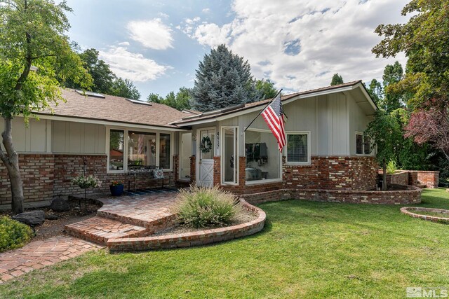 back of property with a patio and a yard