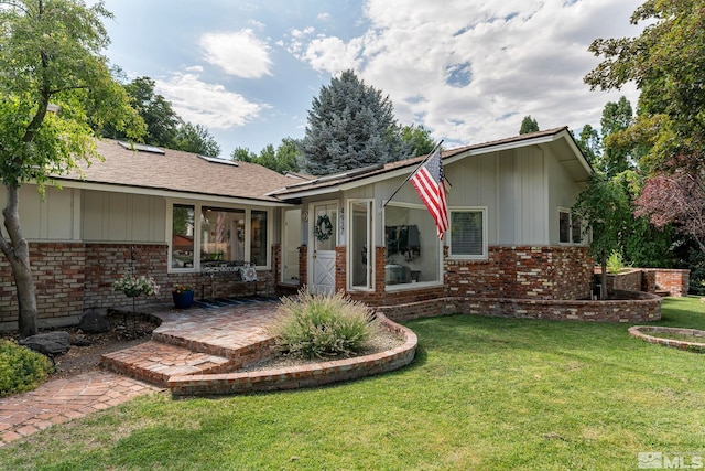 back of property with a lawn and a patio