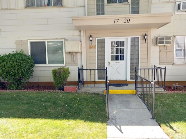 doorway to property with a yard and a wall mounted AC