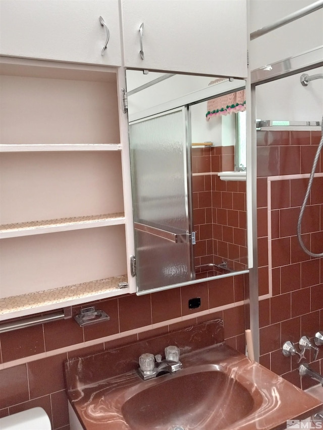 bathroom with tile walls, sink, tasteful backsplash, and walk in shower