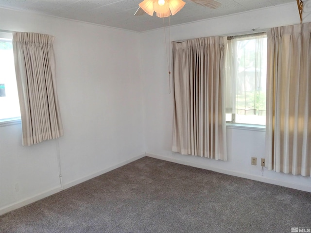 carpeted spare room with ceiling fan and plenty of natural light