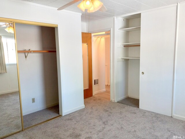 unfurnished bedroom featuring light carpet and ceiling fan