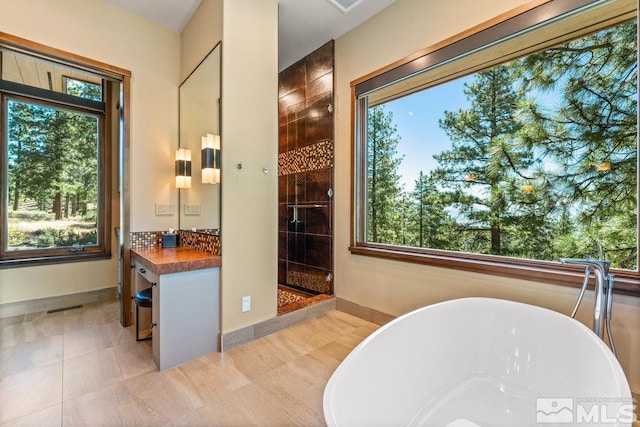 bathroom featuring vanity, shower with separate bathtub, tile patterned flooring, and decorative backsplash