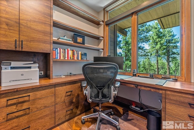 office with hardwood / wood-style flooring, a healthy amount of sunlight, and built in desk