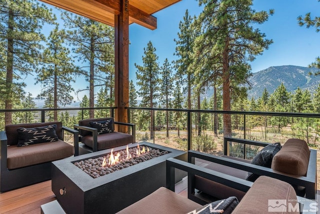 wooden deck with a mountain view and a fire pit