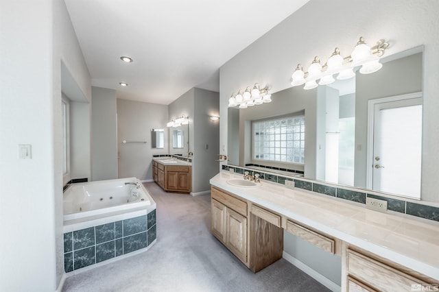 bathroom featuring dual vanity, tiled bath, and backsplash