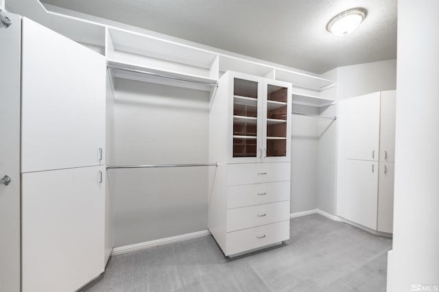 walk in closet featuring light carpet