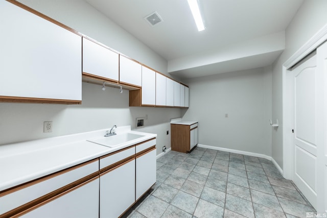 kitchen with sink, white cabinets, and light tile patterned floors