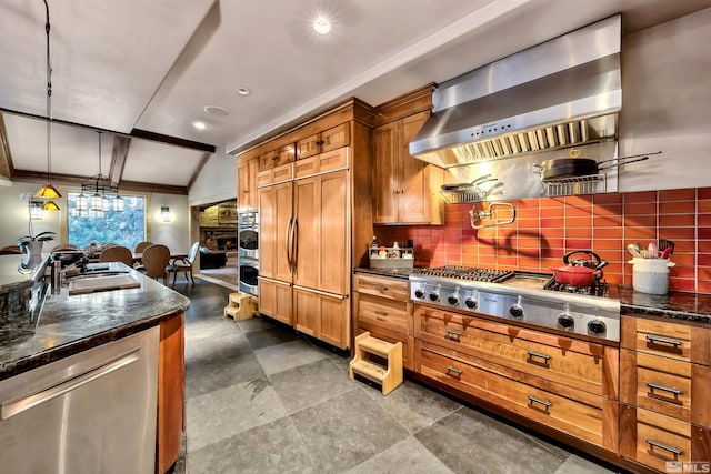 kitchen featuring wall chimney range hood, appliances with stainless steel finishes, decorative backsplash, pendant lighting, and sink