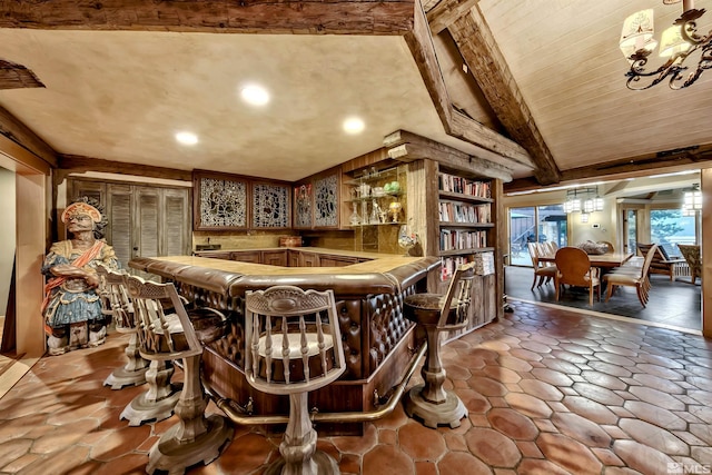 bar featuring hanging light fixtures, tile patterned floors, vaulted ceiling with beams, and a chandelier