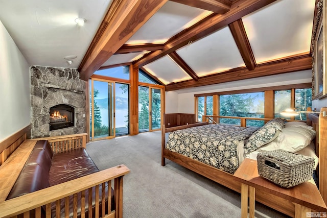 carpeted bedroom featuring multiple windows, a fireplace, and lofted ceiling with beams