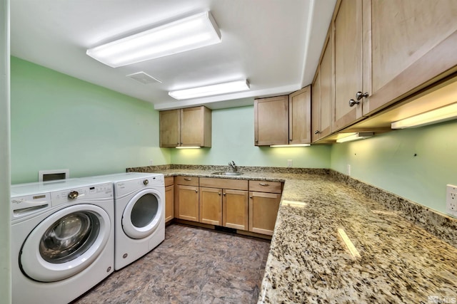 washroom with washing machine and dryer, dark tile patterned flooring, and cabinets