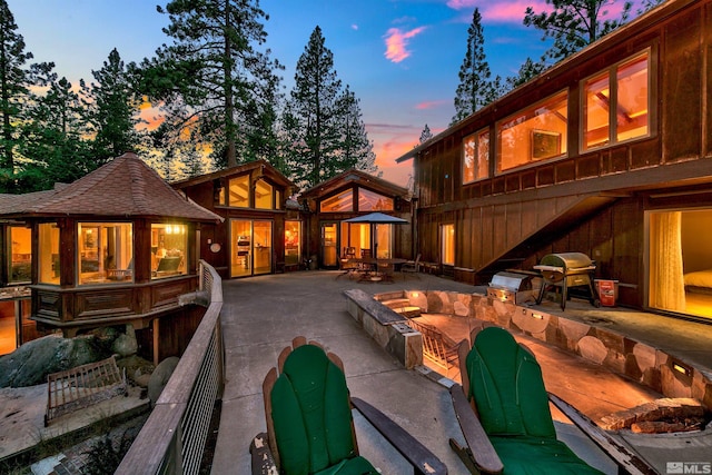 back house at dusk with a patio