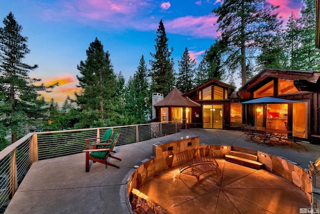 back house at dusk with a patio area