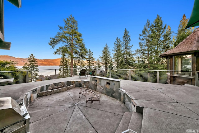 view of patio / terrace with a water and mountain view